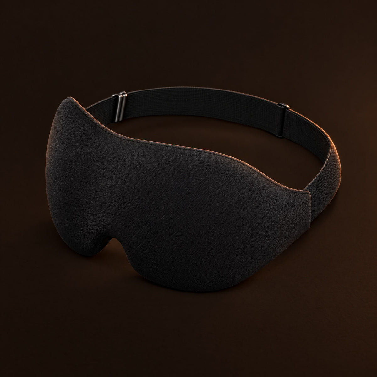 Black 3D contoured blackout sleep mask on a dark background