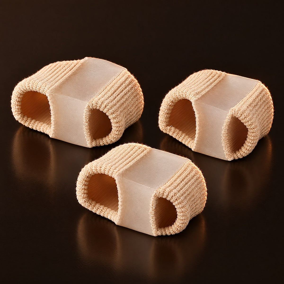 Beige gel toe separator sleeves on a dark background